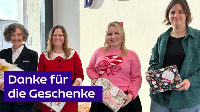 Vier Frauen halten Geschenke in Weihnachtspapier in den Händen