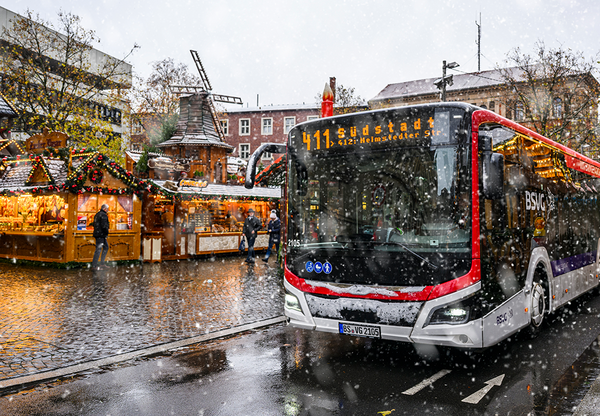 Die Buslinie 411 auf der Münzstraße bei der Durchfahrt durch den Weihnachtsmarkt.